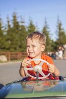 A boy driving a children's car. Joyful emotions. Children, portrait. photo