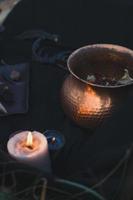 Close up witch cauldron and burning candle concept photo