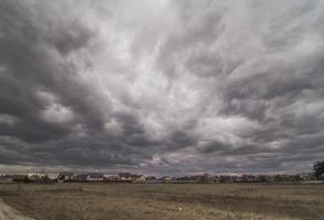 Heavy storm clouds above countryside landscape photo