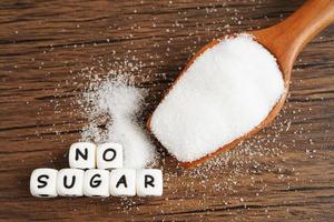 sin azúcar, azúcar granulada dulce con texto, prevención de diabetes, dieta y pérdida de peso para una buena salud. foto