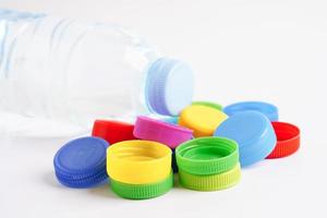tapas de botellas de plástico de colores para reciclar sobre fondo blanco. foto