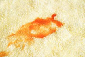 mancha de salsa picante sucia en la tela para lavar con detergente en polvo, limpieza del concepto de tareas domésticas. foto