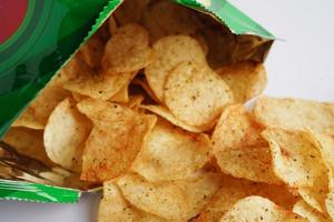 Potato chips in open bag, delicious BBQ seasoning spicy for crips, thin slice deep fried snack fast food in open bag. photo