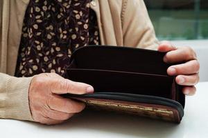 Retired elderly woman counting coins money and worry about monthly expenses and treatment fee payment. photo