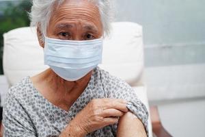 Asian elder senior woman patient getting coronavirus vaccine. photo