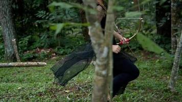 mujeres asiáticas corriendo rápidamente en la jungla mientras sostienen una flecha y un arco video