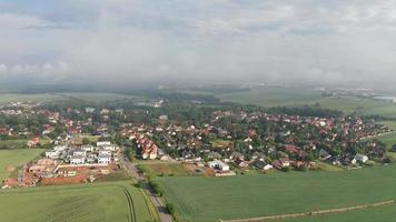 aerial backwards view of a foggy village and clouds video