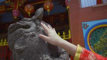 una hermosa mujer china tocando la estatua china mientras visita el templo budista video
