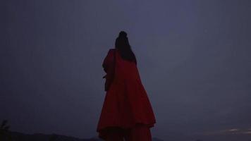 A Chinese woman doing body movements on the hill during the dark morning video