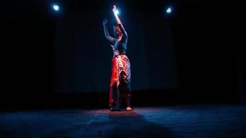 een danser Actie hun lichaam met de ritme terwijl dansen Aan de stadium licht video