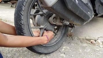 Motorcycle repair shop on the side of the road, repairing motorcycle tires. video