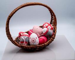 wicker basket with colored easter eggs, on a white background in the period of easter 2023 photo