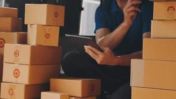 Entrepreneurs Small Business SME Independent men work at home Use Ipad for commercial checking, online marketing, packing boxes, SME sellers, concept, e-commerce team, online sales video