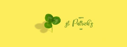 Happy St. Patrick's Day text with clover leaf on colored background. Greeting banner photo