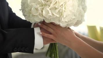 Groom gives the bride a wedding bouquet close up video