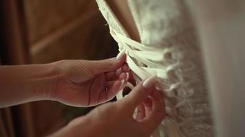 bridesmaid ties laces on wedding dress video