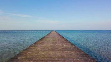 ein Flug über einen Holzsteg im Meer. video