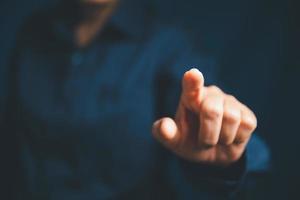 Closeup of businesswoman hand on empty dark blue background in office for design work, insert icon bundle or business technology symbols or other. selective focus on hand. female online working photo