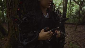 belle femme asiatique chillin à l'arbre dans un costume noir video