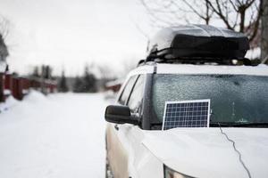 Portable solar panel on SUV car at winter. photo