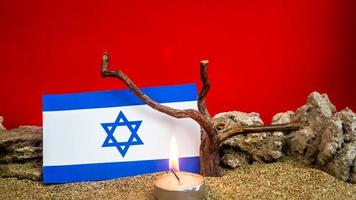 Israeli flag and candles burning in front of it, Holocaust memory day photo