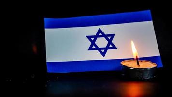 Israeli flag and candles burning in front of it, Holocaust memory day photo