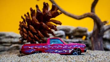 toy car hauling pinecones on an orange background photo