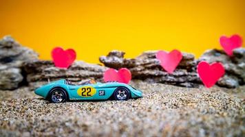 Minahasa, Indonesia  December 2022, toy car with gradient orange background and a heart photo