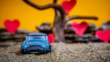 Minahasa, Indonesia  December 2022, toy car with gradient orange background and a heart photo