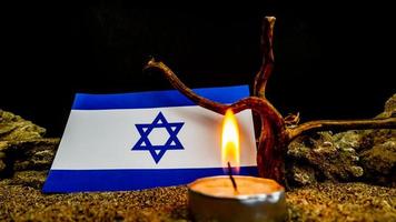 Israeli flag and candles burning in front of it, Holocaust memory day photo