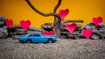 Minahasa, Indonesia December 2022, toy car with gradient orange background and a heart photo