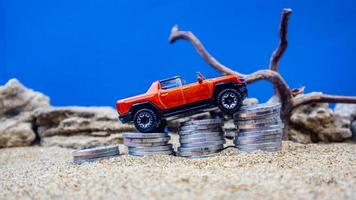 minahasa, Indonesia  January 2023, toy car on a pile of coins, saving for the future, managing successful transportation business technology concept photo