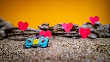 Minahasa, Indonesia  December 2022, toy car with gradient orange background and a heart photo