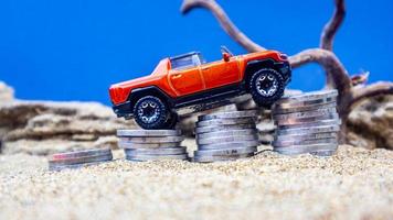 minahasa, Indonesia  January 2023, toy car on a pile of coins, saving for the future, managing successful transportation business technology concept photo