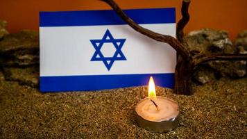 Israeli flag and candles burning in front of it, Holocaust memory day photo