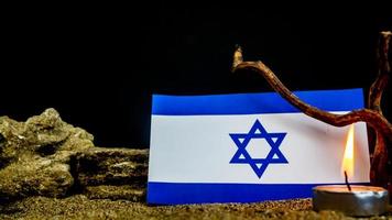 Israeli flag and candles burning in front of it, Holocaust memory day photo