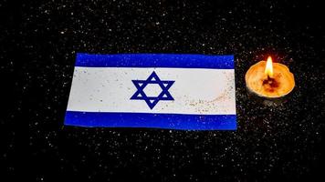 Israeli flag and candles burning above it, Holocaust memory day photo