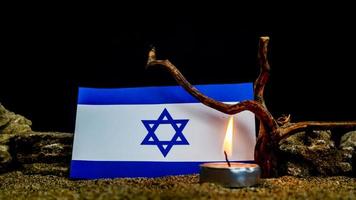 Israeli flag and candles burning in front of it, Holocaust memory day photo