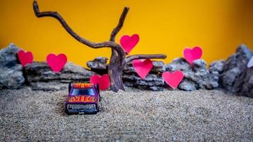 Minahasa, Indonesia  December 2022, toy car with gradient orange background and a heart photo