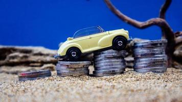 minahasa, Indonesia  January 2023, toy car on a pile of coins, saving for the future, managing successful transportation business technology concept photo