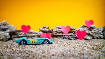 Minahasa, Indonesia  December 2022, toy car with gradient orange background and a heart photo