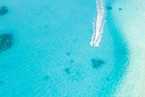 Aerial photo of water sport in Maldives. Landscape seascape aerial view over Maldives atoll sandbank island. Jet ski at the white sandy beach. Summer vacation and recreational concept