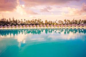 puesta de sol en la isla de maldivas, resort de villas acuáticas. maldivas playa paisaje de lujo sobre bungalows de agua. paisaje exótico de vacaciones de verano y fondo de vacaciones foto