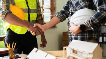 Engineer and contractor join hands after signing contract,They are having a building project together. successful cooperation concept photo