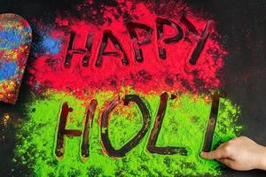 Happy holi inscription children's hand writes. .Holi background with colored powder. photo