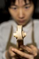 young Chinese violin maker at work in her workshop photo