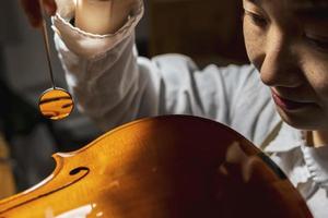 young Chinese violin maker at work in her workshop photo