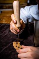 young Chinese woman violin maker signs the jumper of her violin with fire with her name photo