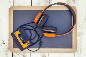 vintage audio cassettes and headphones over a black chalkboard photo