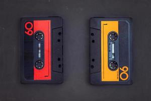 pair of vintage audio cassettes over a black chalkboard photo